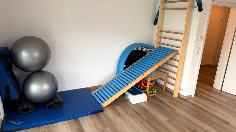 Bewegungsraum mit Gymnastikbällen, Matten und Rollenrutsche