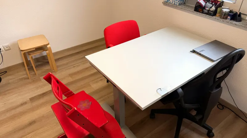 Arbeitstisch im Logopädie-Raum mit Kinderstuhl