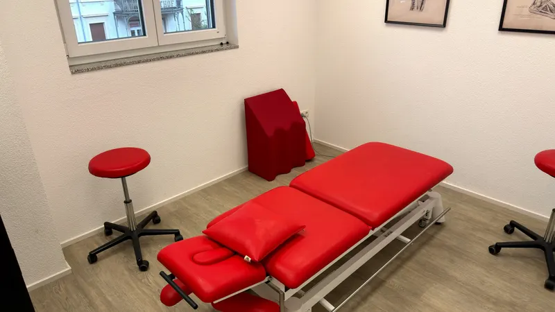 Behandlungsraum der Physiotherapie mit Liege und Hockern